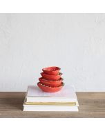 A vibrant red strawberry cup sits atop a stack of assorted books, merging the themes of literature and culinary delight.