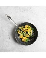 A frying pan filled with a colorful assortment of fresh vegetables, including bell peppers and zucchini.