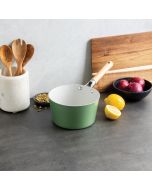  A green frying pan with wooden utensils rests on a kitchen counter, showcasing a clean and organized cooking space.
