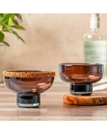 Two small bowls placed on a wooden table, showcasing their simple design and natural texture of the wood.