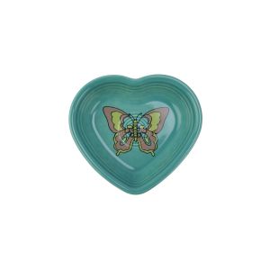 A Fiesta Small 9oz heart bowl is photographed against a clean white background. The Heart-shaped bowl is glazed in fiestas turquoise, a blue-green shade. On the bowl's center, a hand-drawn illustration of a butterfly is seen in shades of pink and yellow. 