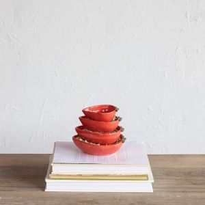 A vibrant red strawberry cup sits atop a stack of assorted books, merging the themes of literature and culinary delight.