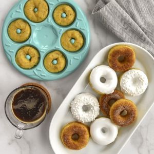 A plate featuring an assortment of colorful donuts alongside a steaming cup of coffee.