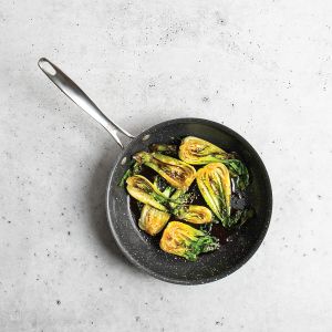 A frying pan filled with a colorful assortment of fresh vegetables, including bell peppers and zucchini.
