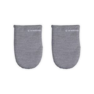 Le Creuset Mitts against a white background, shot directly from above  from the front. A LE Creuset Logo is stitched in white. 