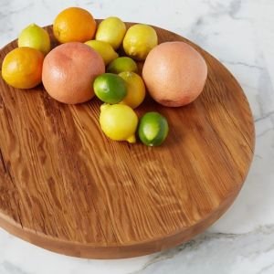 etúHOME Classic Natural Trivet Top Lazy Susan set on a marble surface with an arrangement of fruits 