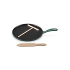 Le Creuset 10.25" Traditional Round Crepe Pan against a white background, shot slightly from above. The t-shaped rake is set atop the pan, and the thin spatula is placed in front of the pan.  Image