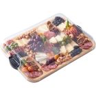 A wooden tray displaying an assortment of cheese, cured meats, and fresh fruit arranged artfully. Image