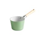 A green saucepan rests on a counter beside a wooden cutting board, creating a cozy kitchen scene. Image