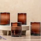 Four brown glass vases arranged on a wooden stand, showcasing a minimalist and elegant design. Image