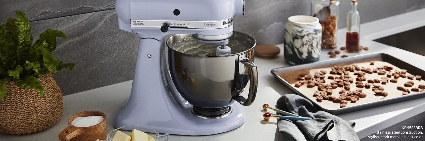 薰衣草KitchenAid台式搅拌机和黑色不锈钢碗的照片。