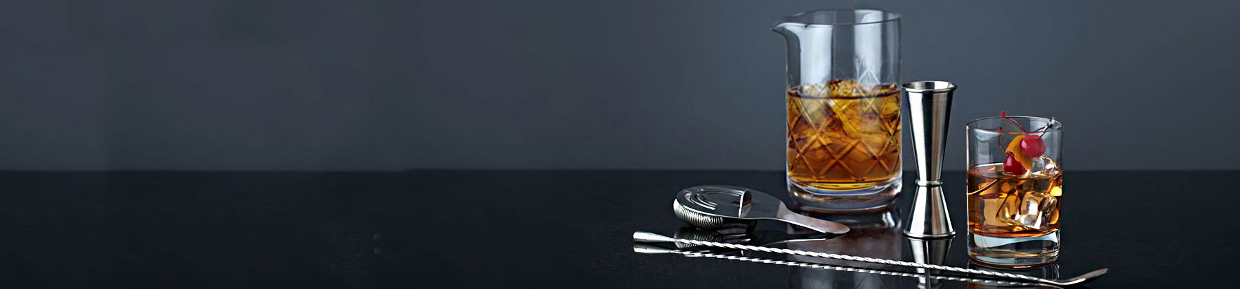 Photo of Viski barware on a black table, with barware stirrers and accessories near.