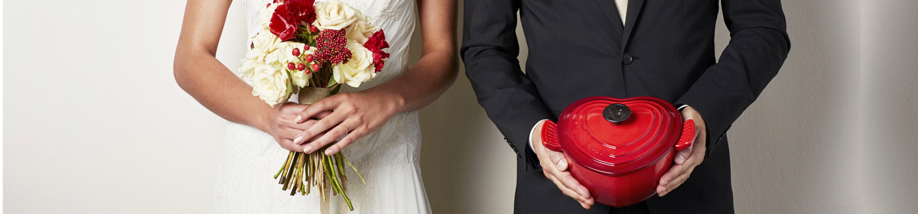 Bride and Groom with Le Creuset heart shaped, red Dutch Oven.