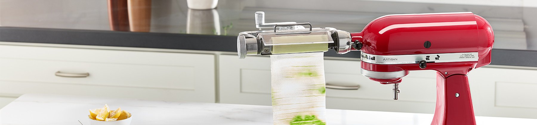 Photo of a KitchenAid Sheet Cutter Attachment cutting cucumber on a KitchenAid mixer.
