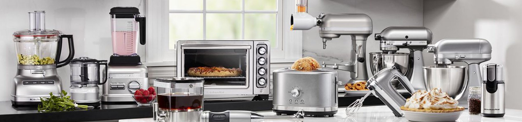 Photo KitchenAid silver product line-up including food processor, blender, convection oven, toaster, cold brew coffeemaker, hand mixer, stand mixers, etc.